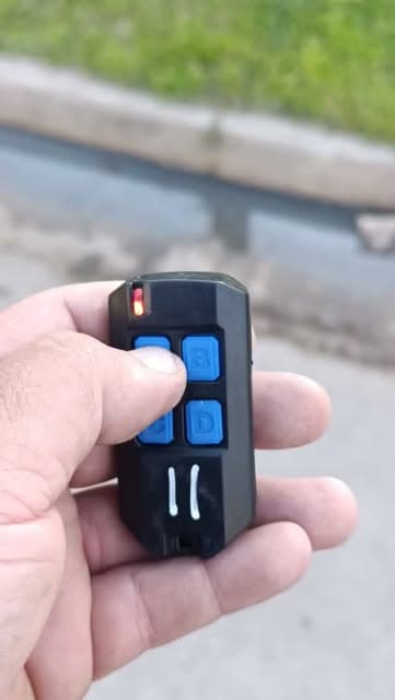 Vecino de Longchamps sosteniendo el control remoto de la alarma vecinal
