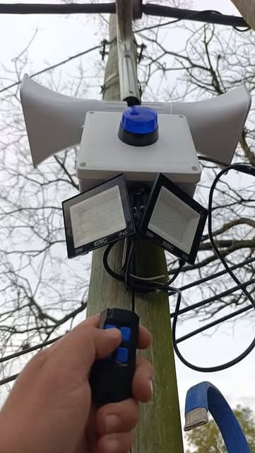Kit Premium Balizas instalado en un poste: dos sirenas, dos reflectores y baliza azul, activado con el control remoto