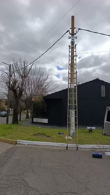 Técnico instalando una alarma vecinal en un poste de la calle Albarracín, Temperley